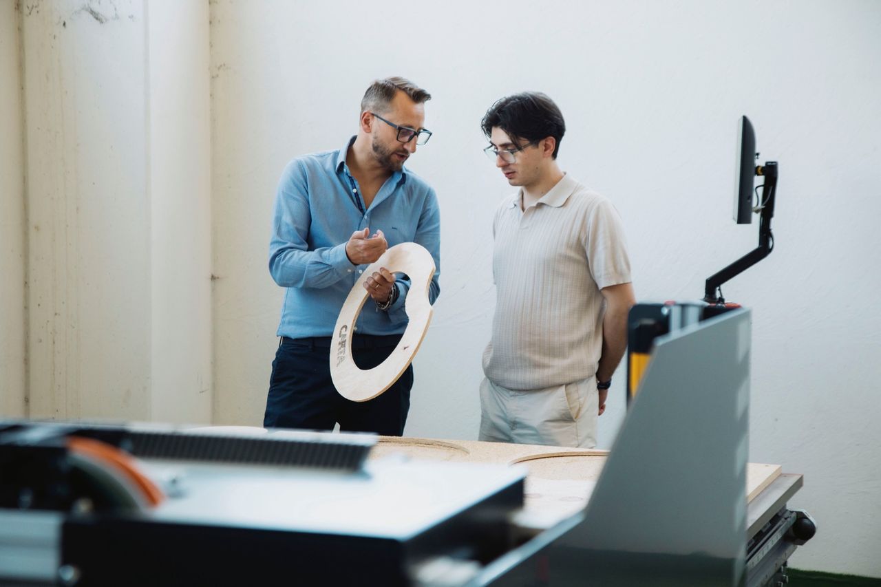 Angelo Cava mostra un anello di legno con una scritta fresata