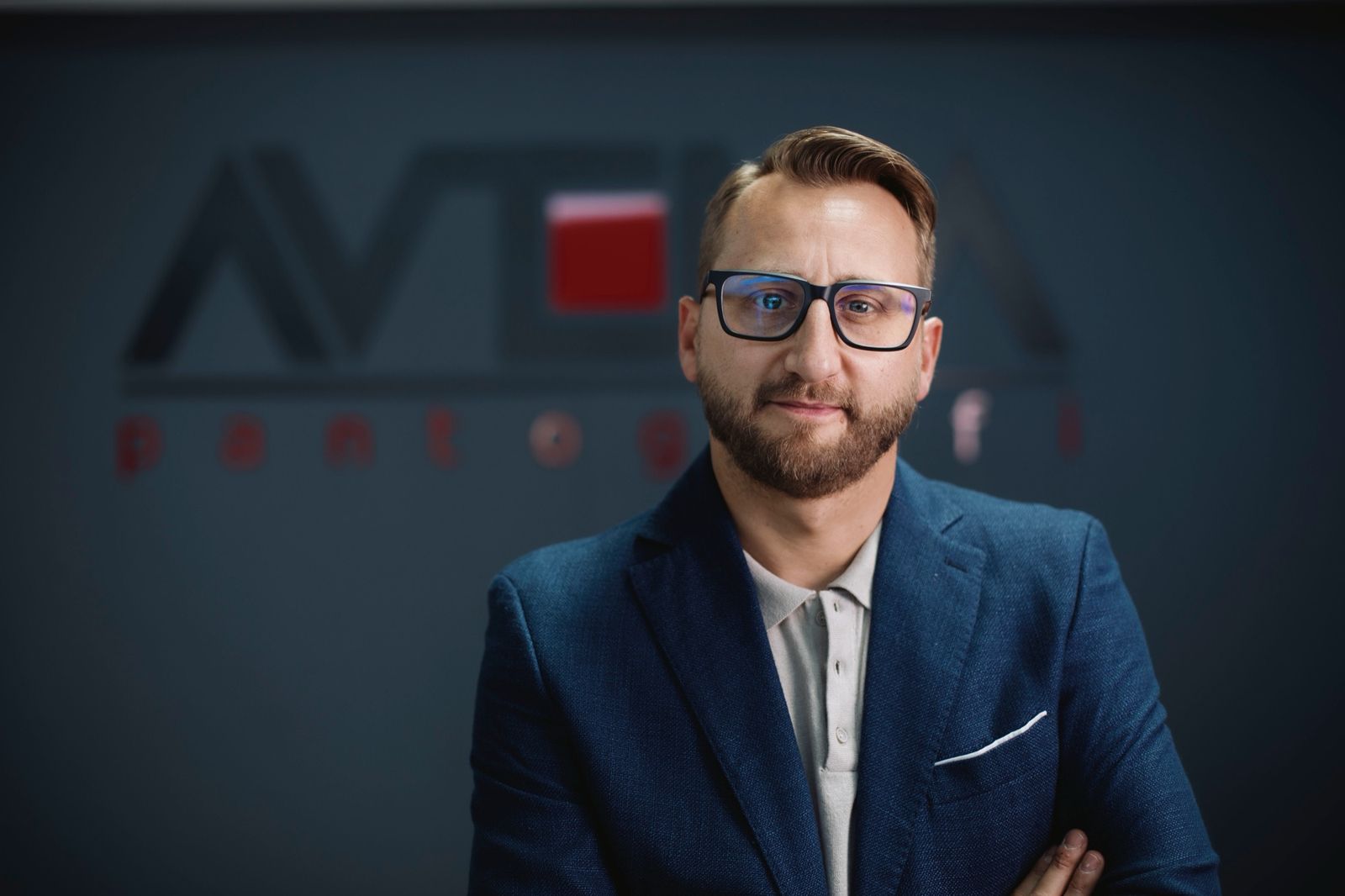 Primo piano di Angelo Cava su sfondo scuro con il logo
