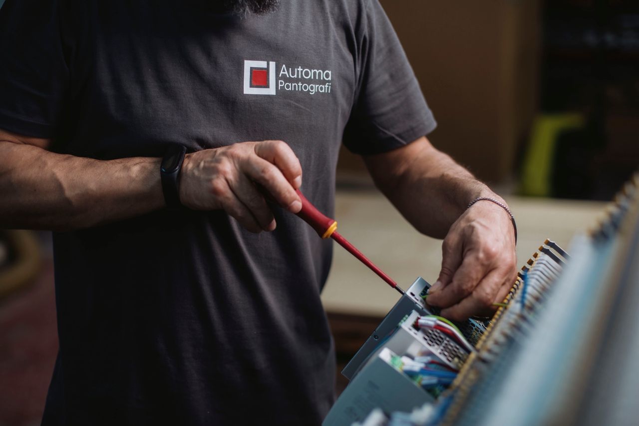 Le mani di un tecnico con il cacciavite sul quadro elettrico