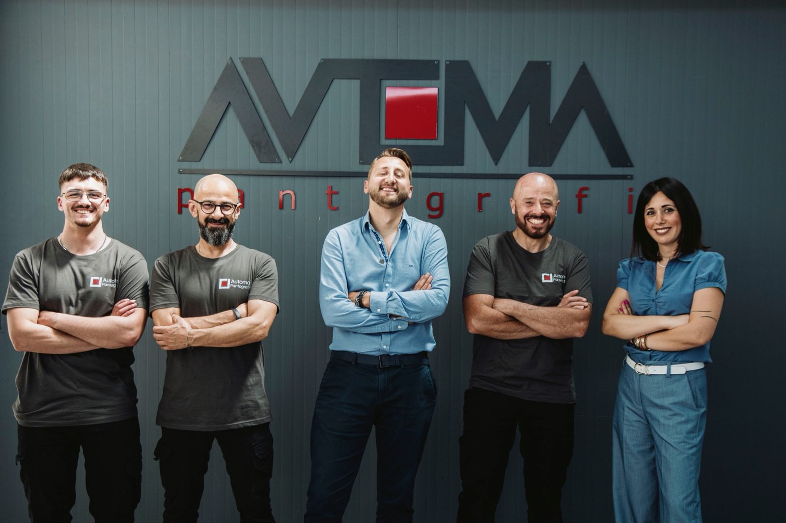 Il team Automa, cinque persone davanti al logo in officina, con Angelo Cava al centro