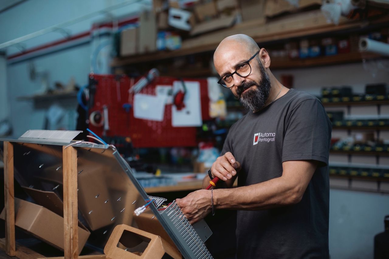 A technician wiring an electrical cabinet at the bench