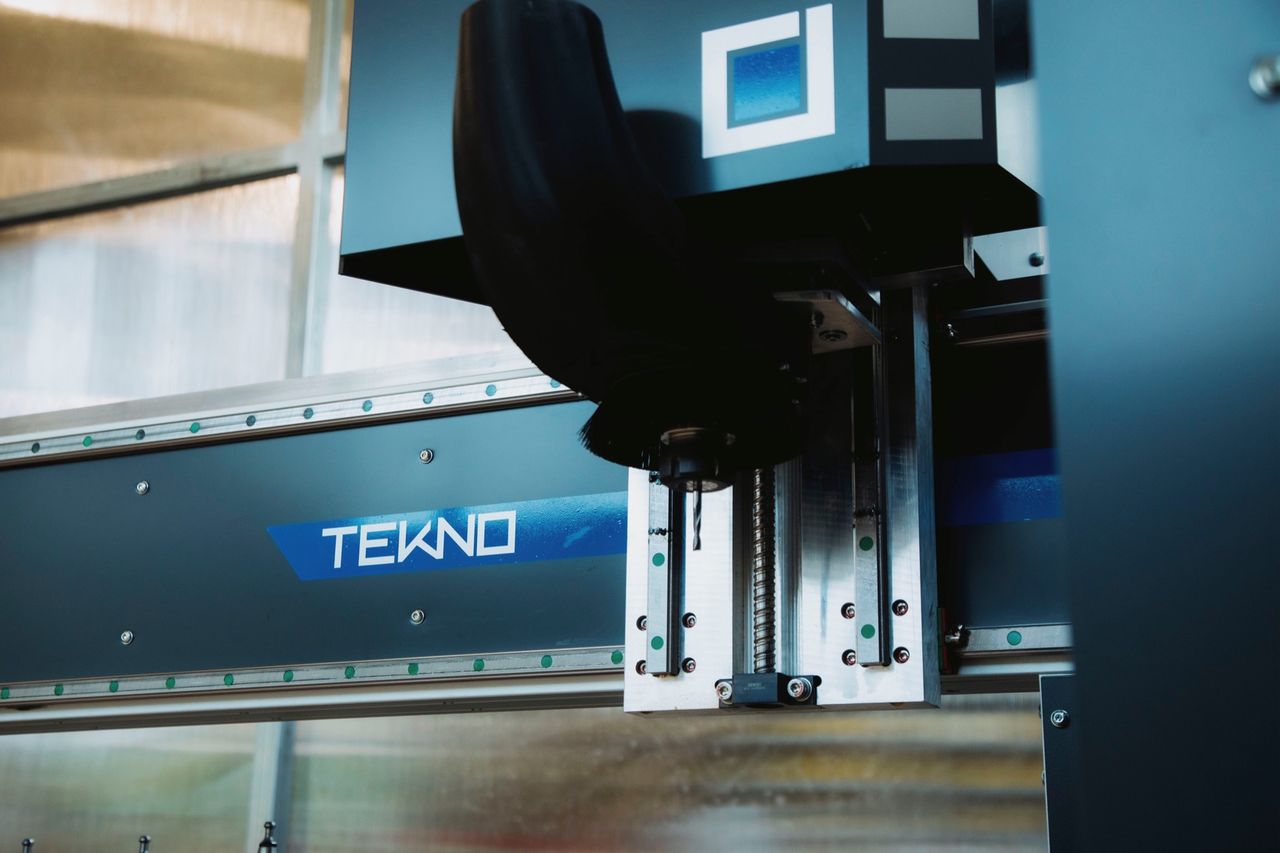 Low-angle view of the TEKNO gantry and logo