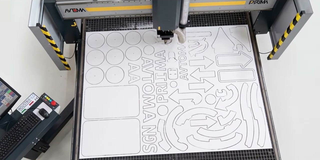 Lettere e sagome tagliate in un pannello bianco sulla PRIMA